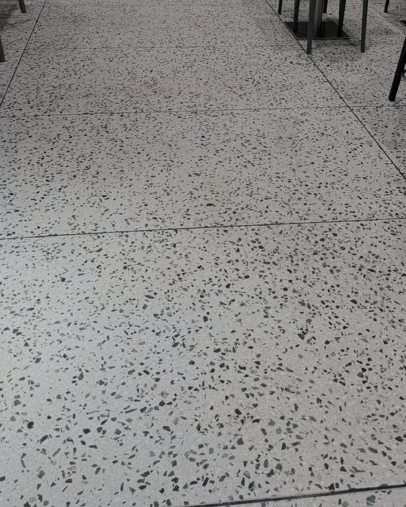 Polerat terrazzogolv med svarta stenkorn i närbild